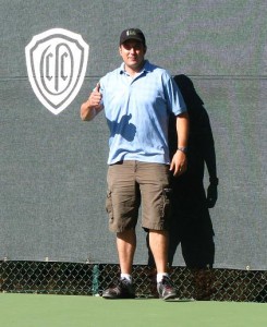 Evan Campodonico standing next to a custom logo windscreen at Orinda Country Club
